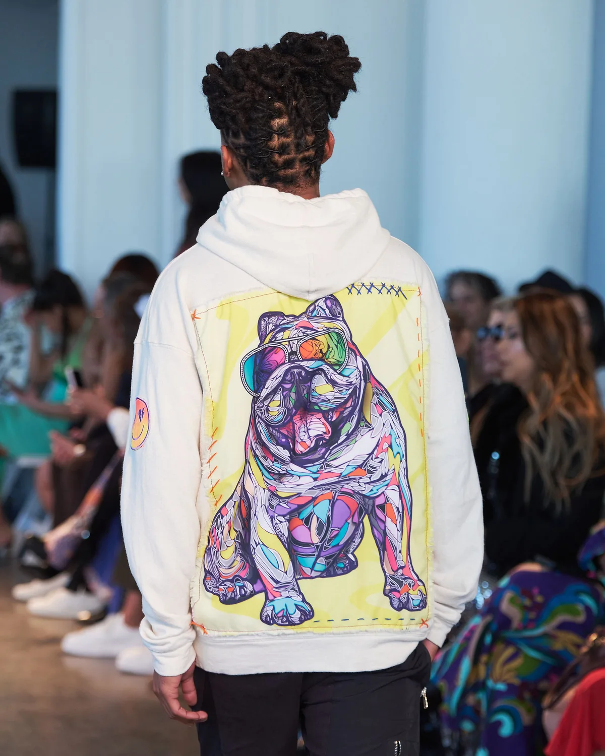 Model on the FDLA runway in a cream hoodie printed with Ramiro Alban’s vivid bulldog artwork