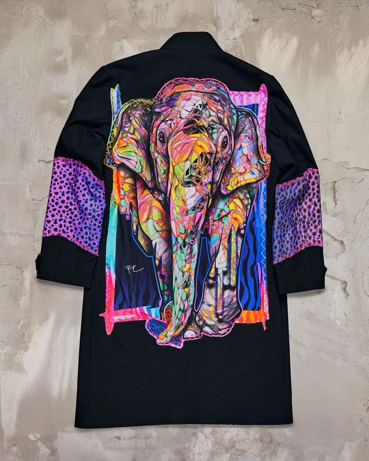 Studio shot of a long coat printed with a richly coloured elephant portrait